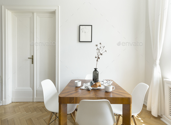 White chairs at wooden table in minimal dining room interior wit